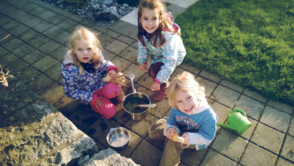 3 children playing bubbles outside